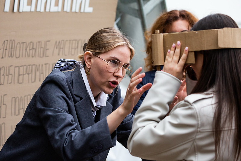 A Cardboardia member explaining something at an outdoor workshop table
