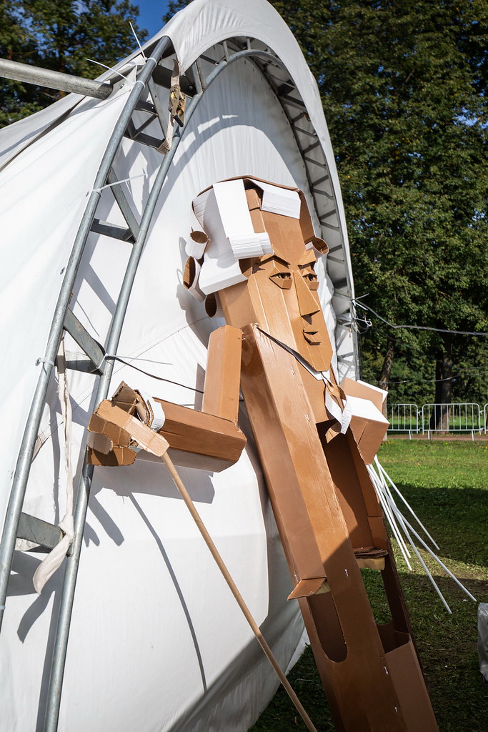 A life-size cardboard figure with a cane, leaning against a tent