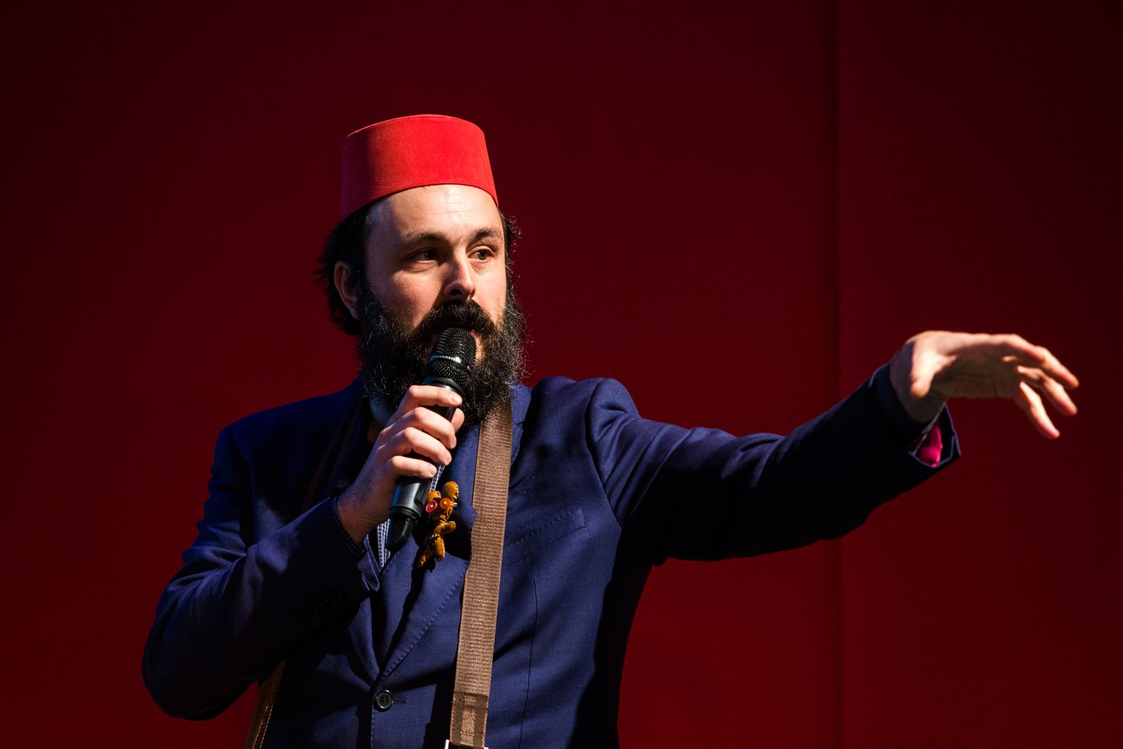 Cardboardia's founder speaking on stage in a red fez hat
